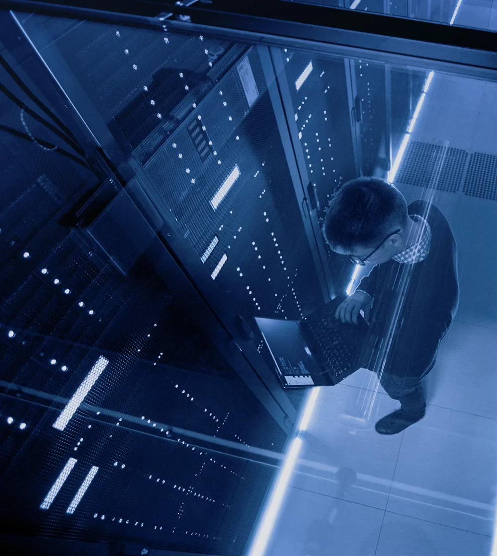 Man working with a computer in an enclosed facility for government IT solutions.