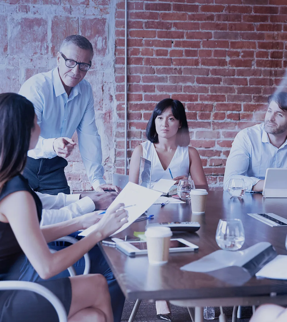 Team of professionals in a meeting. Coworkers communicate in person in an office.